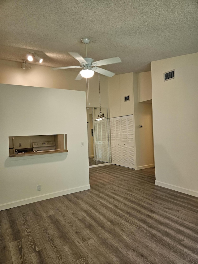 spare room featuring dark wood-type flooring, ceiling fan, and a textured ceiling