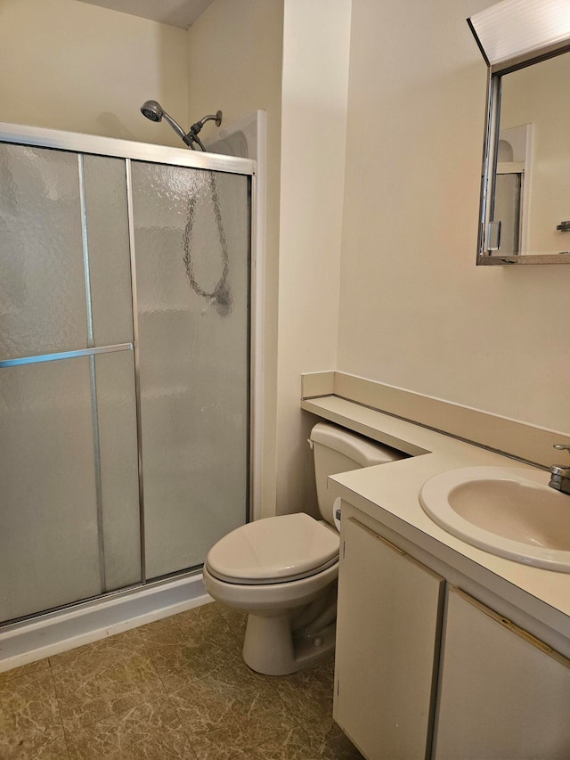 bathroom featuring toilet, vanity, and walk in shower