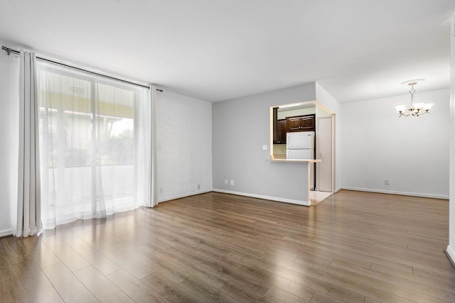 unfurnished room with hardwood / wood-style floors and a chandelier