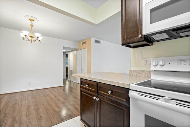 kitchen featuring pendant lighting, white appliances, light hardwood / wood-style flooring, a notable chandelier, and dark brown cabinets