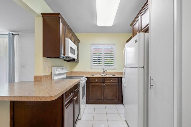 kitchen with kitchen peninsula, sink, light tile patterned floors, and white appliances