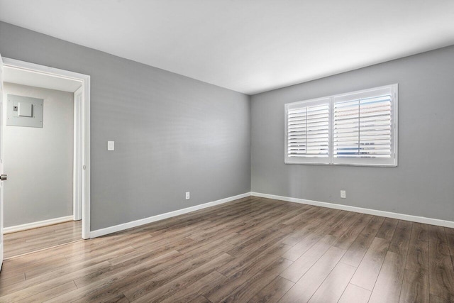 spare room featuring wood-type flooring and electric panel