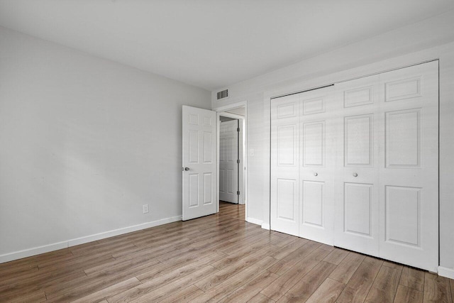 unfurnished bedroom featuring light wood-type flooring and a closet