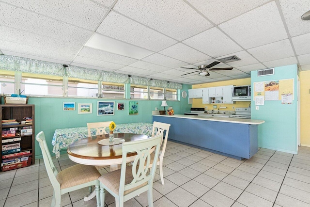 tiled dining area featuring a paneled ceiling and ceiling fan