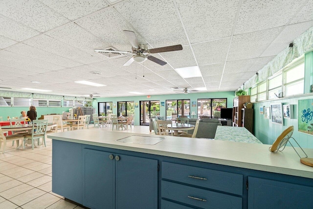 kitchen featuring plenty of natural light, blue cabinets, and light tile patterned floors