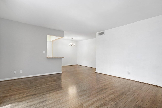 empty room featuring hardwood / wood-style floors and an inviting chandelier