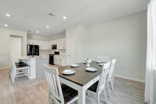 dining room with sink and light wood-type flooring