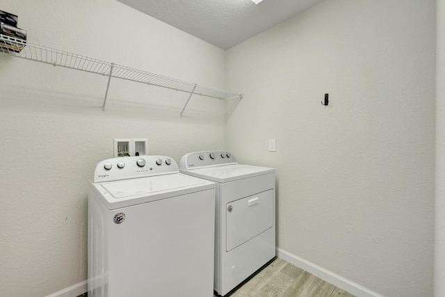 laundry room featuring washer and dryer, light hardwood / wood-style floors, and washer hookup