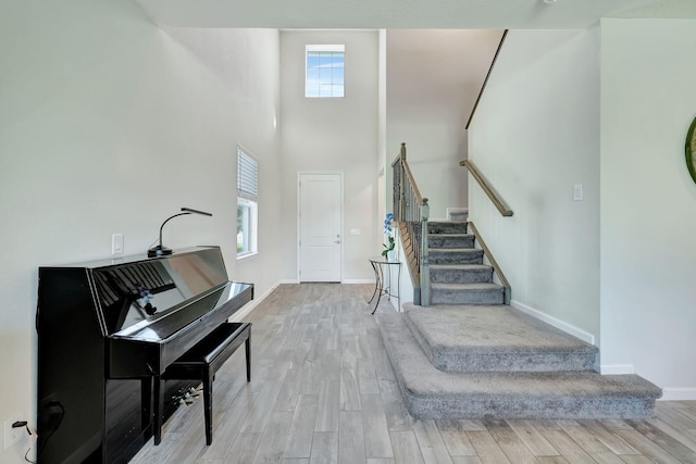 foyer entrance featuring a high ceiling and light hardwood / wood-style flooring