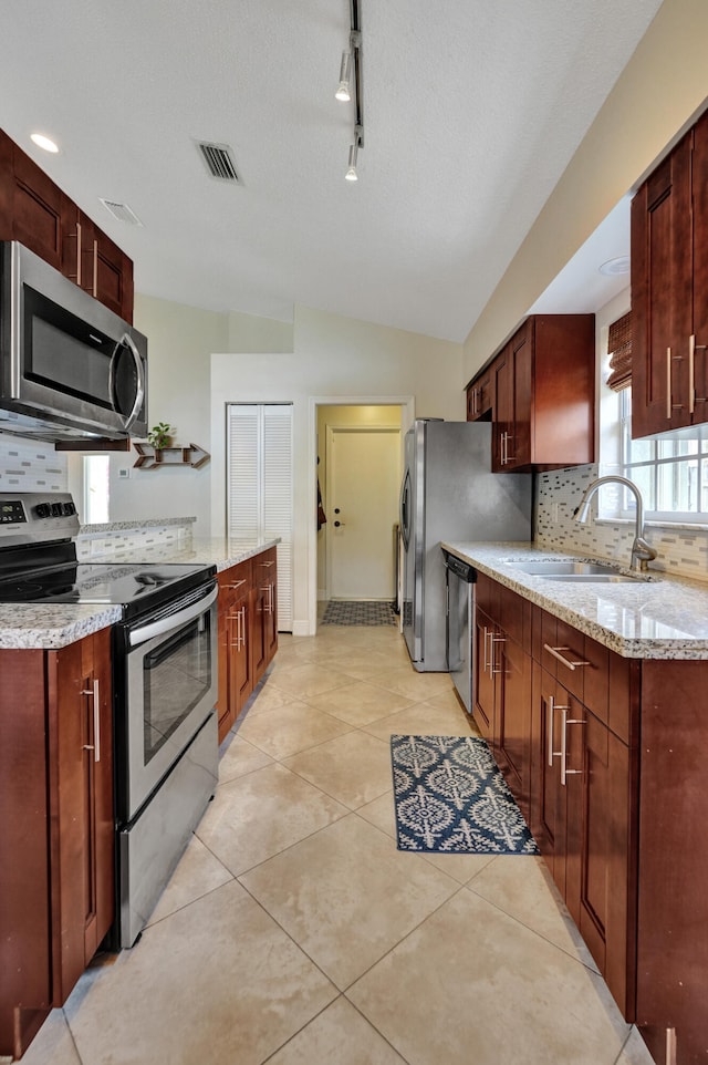 kitchen with light tile patterned floors, visible vents, decorative backsplash, stainless steel appliances, and a sink