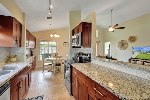 kitchen featuring light tile patterned floors, visible vents, lofted ceiling, stainless steel appliances, and pendant lighting