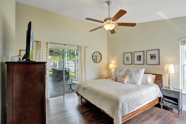 bedroom with dark wood-style floors, high vaulted ceiling, a textured ceiling, and access to exterior