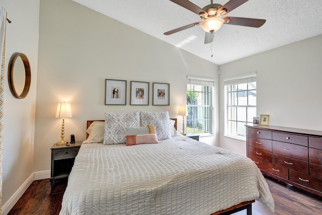 bedroom with lofted ceiling, ceiling fan, a textured ceiling, dark wood-style flooring, and baseboards