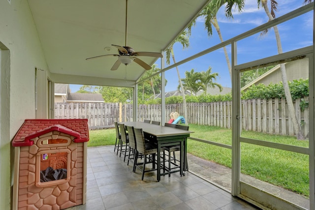 sunroom with vaulted ceiling and a ceiling fan