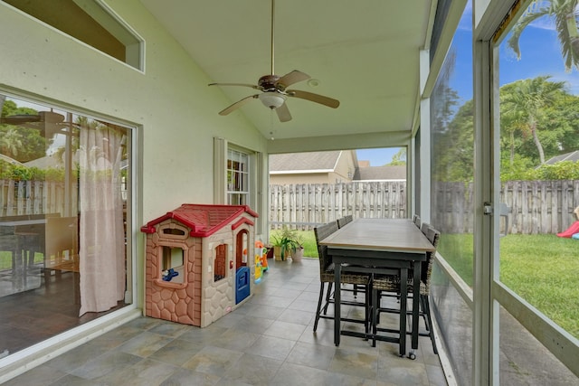 sunroom / solarium with a ceiling fan and vaulted ceiling