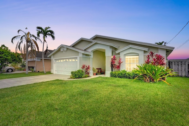 single story home featuring a garage, driveway, a front lawn, and stucco siding