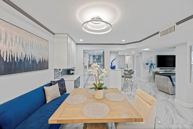 kitchen with a breakfast bar, backsplash, white cabinets, breakfast area, and kitchen peninsula