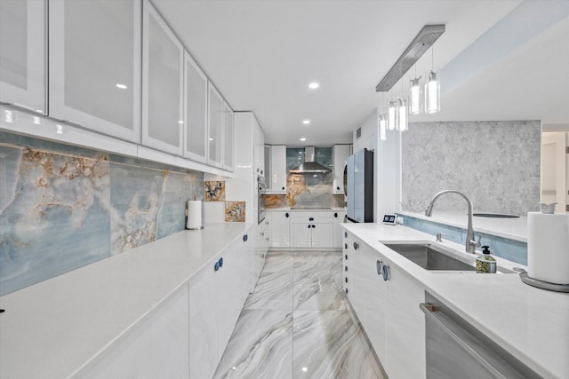 kitchen featuring pendant lighting, sink, wall chimney exhaust hood, black electric cooktop, and white cabinetry