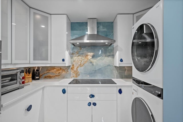 clothes washing area with cabinets and stacked washer / drying machine