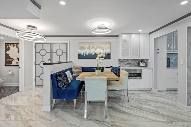 kitchen featuring stacked washer and clothes dryer, oven, wall chimney range hood, tasteful backsplash, and white cabinetry