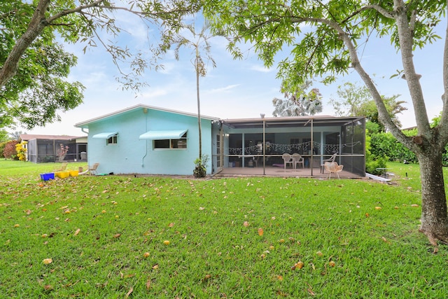 back of house with a patio and a lawn