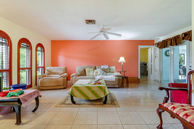 living room with tile floors, a textured ceiling, and ceiling fan