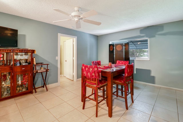 tiled dining room featuring a textured ceiling and ceiling fan