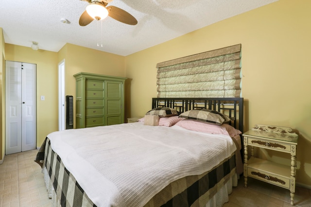 bedroom featuring ceiling fan and a textured ceiling