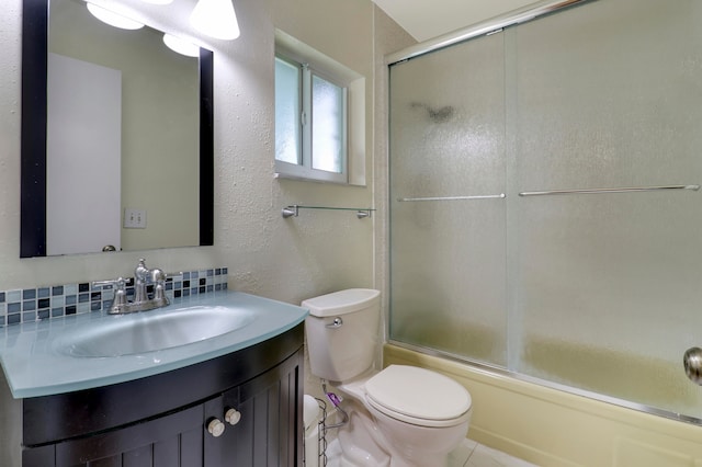 full bathroom with backsplash, toilet, tile floors, bath / shower combo with glass door, and vanity