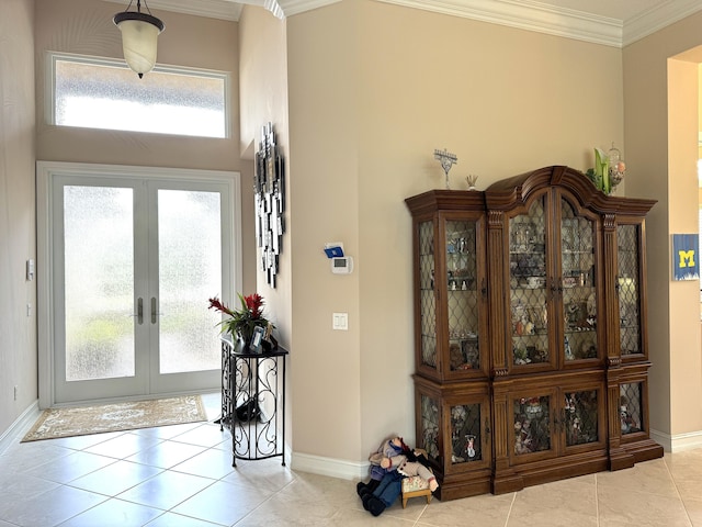 tiled entrance foyer with french doors, crown molding, and a high ceiling