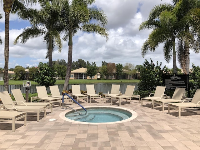 view of pool with a patio area and a hot tub