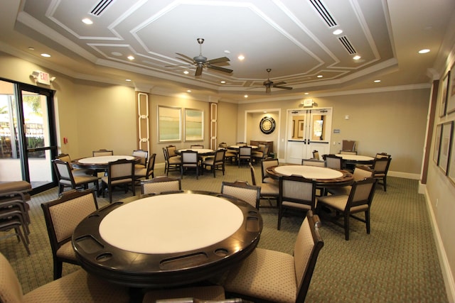 dining space with dark colored carpet, a tray ceiling, ceiling fan, and crown molding