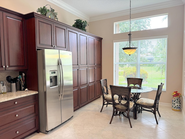 kitchen with backsplash, crown molding, stainless steel refrigerator with ice dispenser, hanging light fixtures, and light stone counters