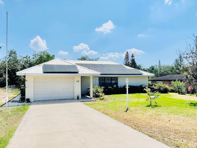 single story home featuring solar panels, a garage, and a front lawn