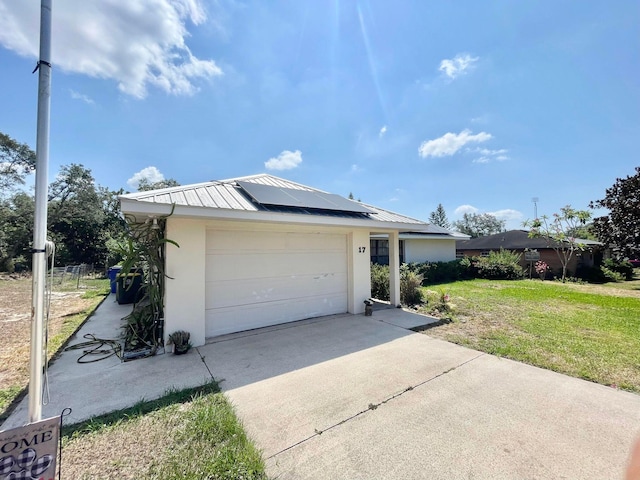 ranch-style house featuring solar panels, a garage, and a front lawn