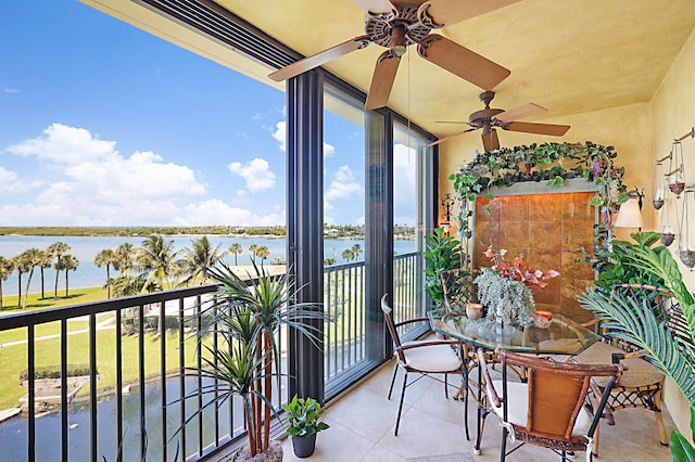 balcony with ceiling fan and a water view