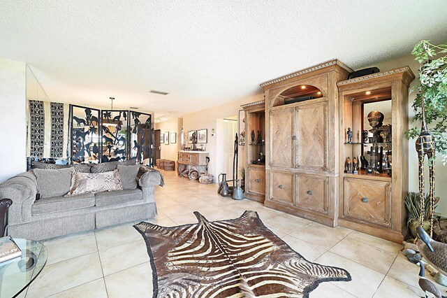 living room with a textured ceiling and light tile floors