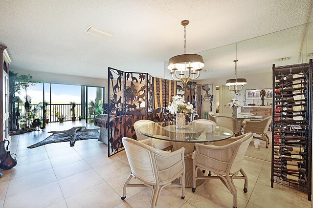 tiled dining area featuring a notable chandelier and a textured ceiling