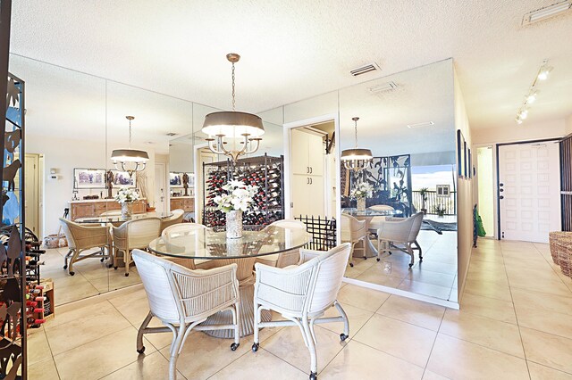 dining room with a textured ceiling, light tile floors, and a chandelier