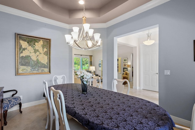 dining area featuring a tray ceiling, tile flooring, crown molding, and a chandelier