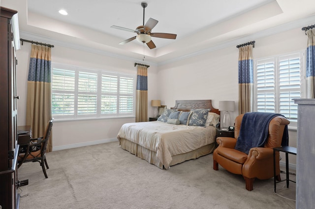 carpeted bedroom featuring a baseboard heating unit, ceiling fan, and a tray ceiling