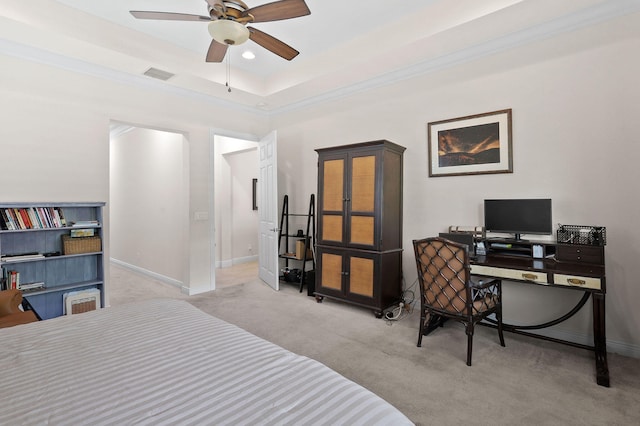 carpeted bedroom with ceiling fan and a raised ceiling