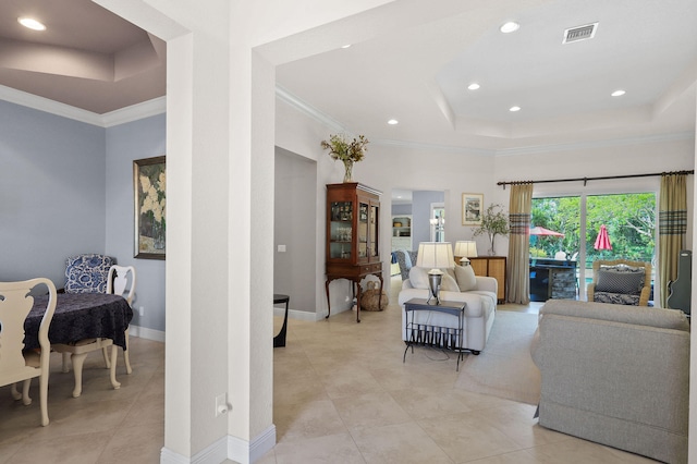 tiled living room featuring ornamental molding and a tray ceiling