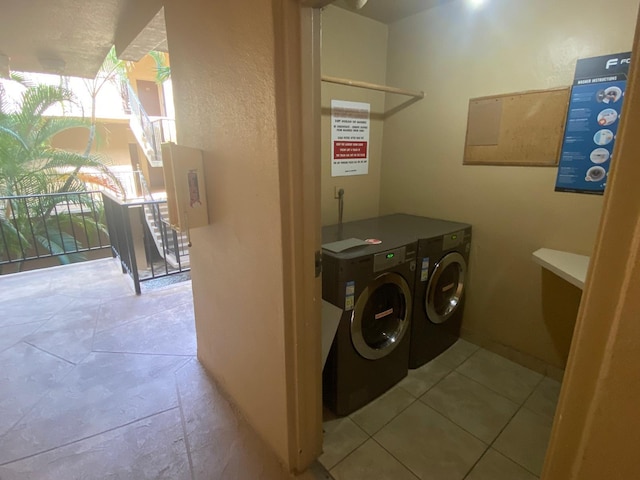 washroom with light tile patterned floors and washer and clothes dryer