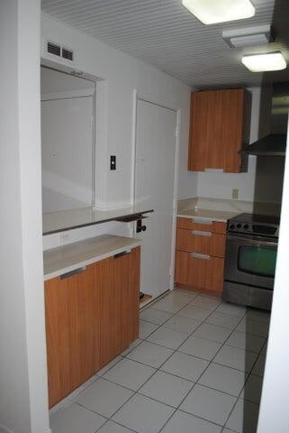 kitchen featuring electric range and light tile patterned flooring