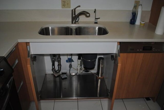 room details featuring light tile patterned floors, dishwashing machine, and sink