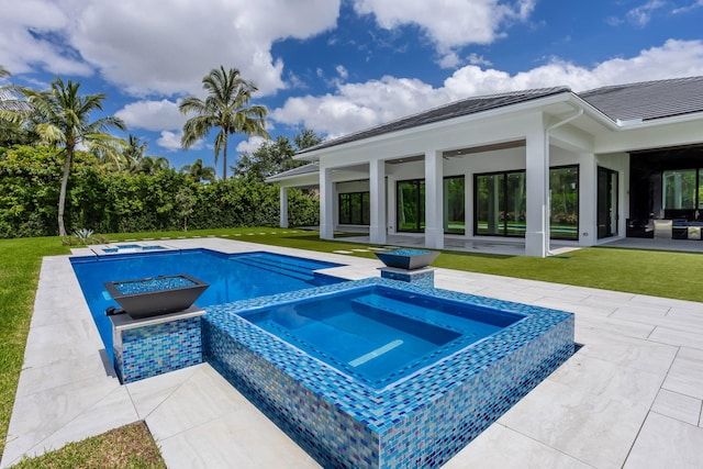 view of swimming pool featuring an in ground hot tub, a patio, and a lawn