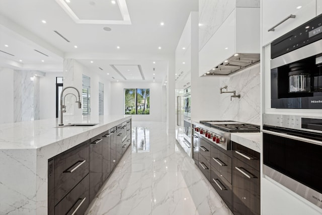 kitchen featuring premium range hood, sink, a large island, white cabinetry, and stainless steel appliances