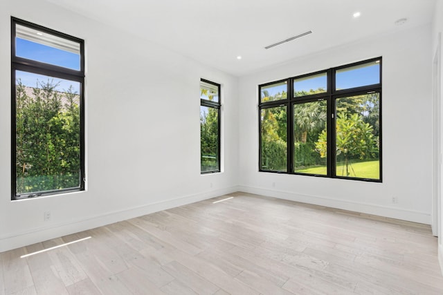 empty room with light hardwood / wood-style flooring and a healthy amount of sunlight