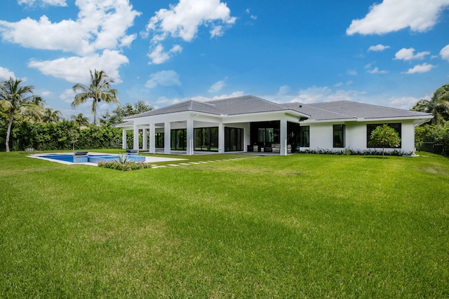 back of property with a lawn and a patio area